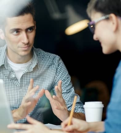 Two people in conversation taking notes